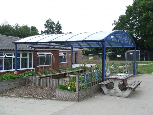 Curved canopy over an outdoor learning and growing area at a primary school