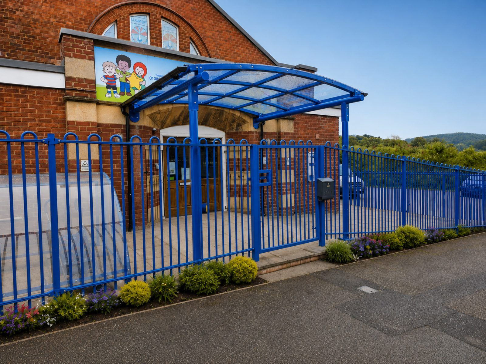 Blue barrel-vault entrance canopy at a school, installed by Canopies & Shelters Ltd