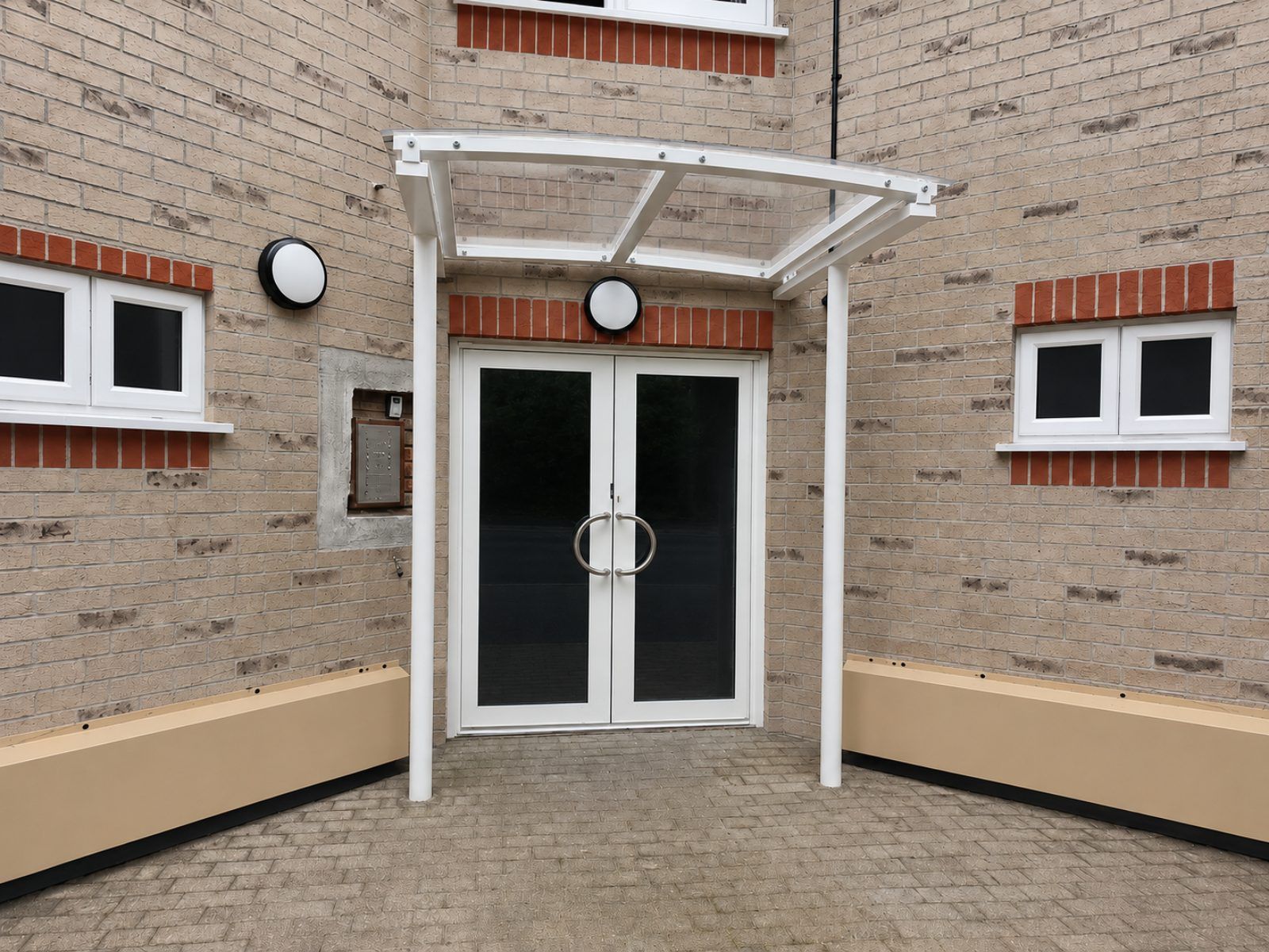 White curved commercial entrance canopy installed by Canopies & Shelters Ltd
