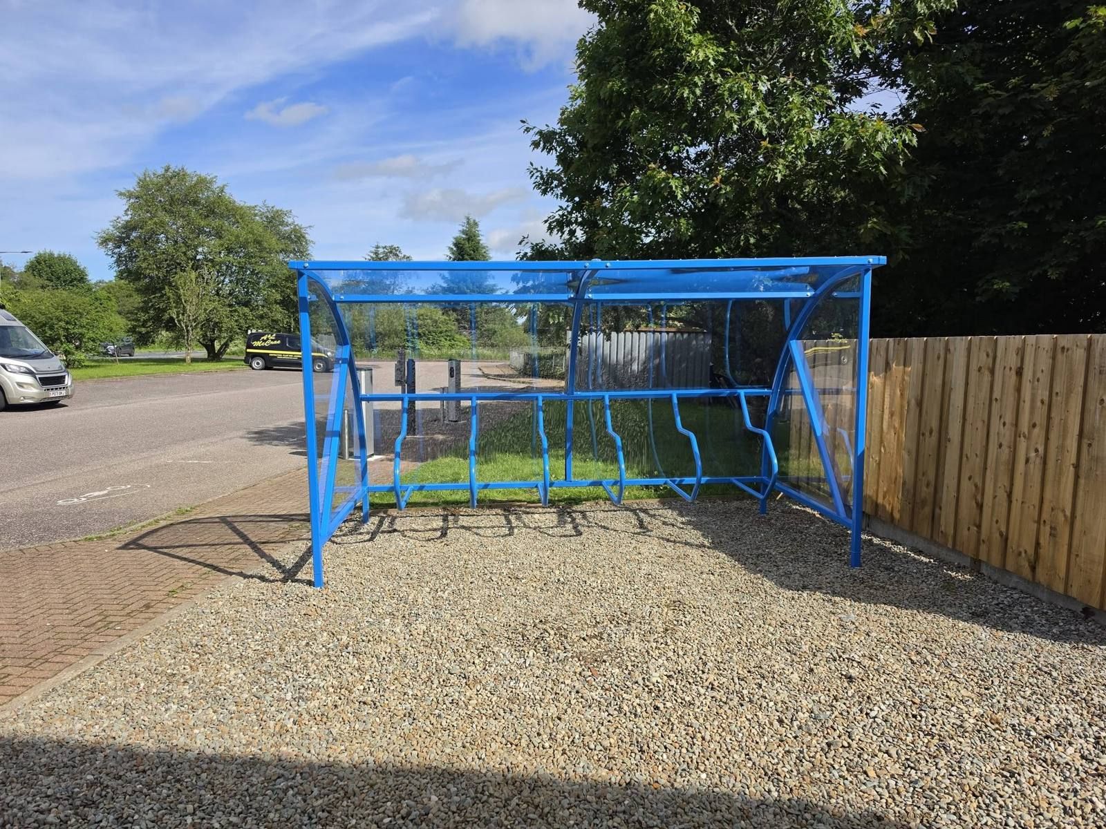 Blue cycle shelter with a clear curved roof at MACPool Activity Hub, Lochgilphead