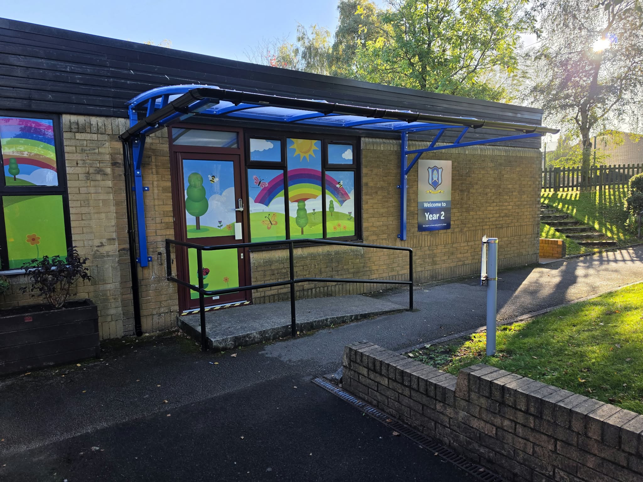 Blue cantilever parent-waiting shelter over the ramped Year 2 entrance at St Richard's RC Primary School, Skelmersdale
