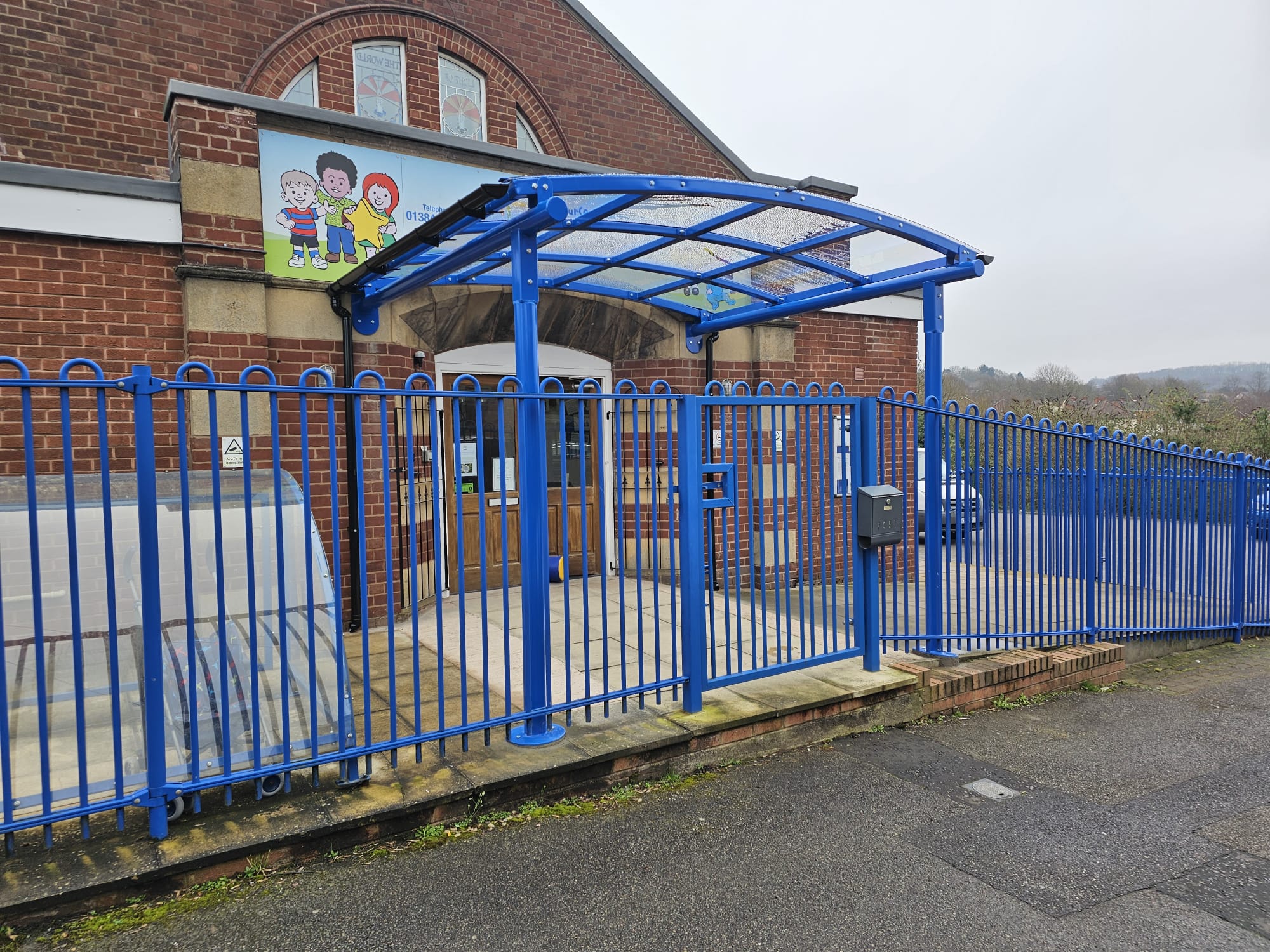 Blue barrel-vault school entrance canopy